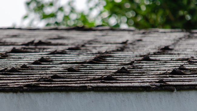 Close-up of curled roofing shingles on a residential rooftop
