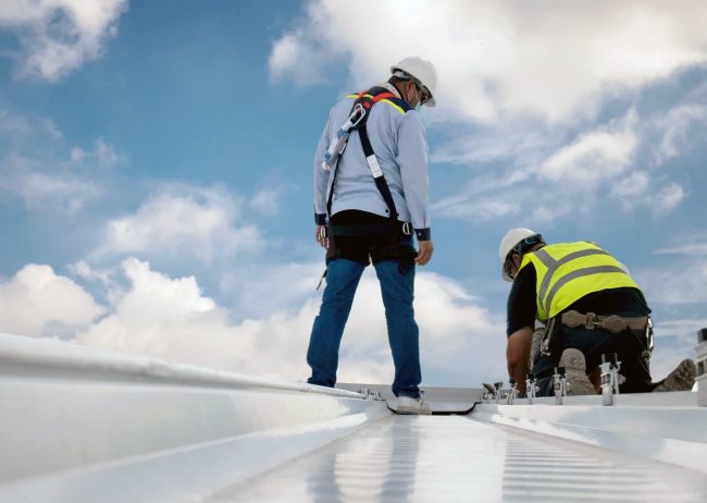 stock-photo-roofer-working-on-roof-structure-of-building-on-construction-site-roofer-using-air-or-pneumatic-1538826422
